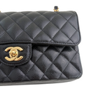 Charger l&#39;image dans la galerie, Black quilted handbag with gold Chanel logo on a white background

