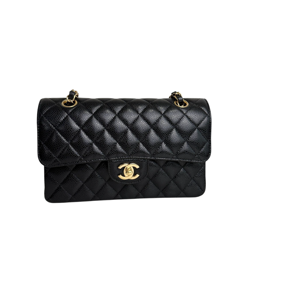 Black quilted handbag with gold hardware on a white background