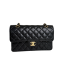 Charger l&#39;image dans la galerie, Black quilted handbag with gold hardware on a white background
