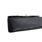 Charger l&#39;image dans la galerie, Black quilted handbag with gold clasp on a white background
