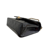 Charger l&#39;image dans la galerie, Black quilted handbag with gold accents on a white background
