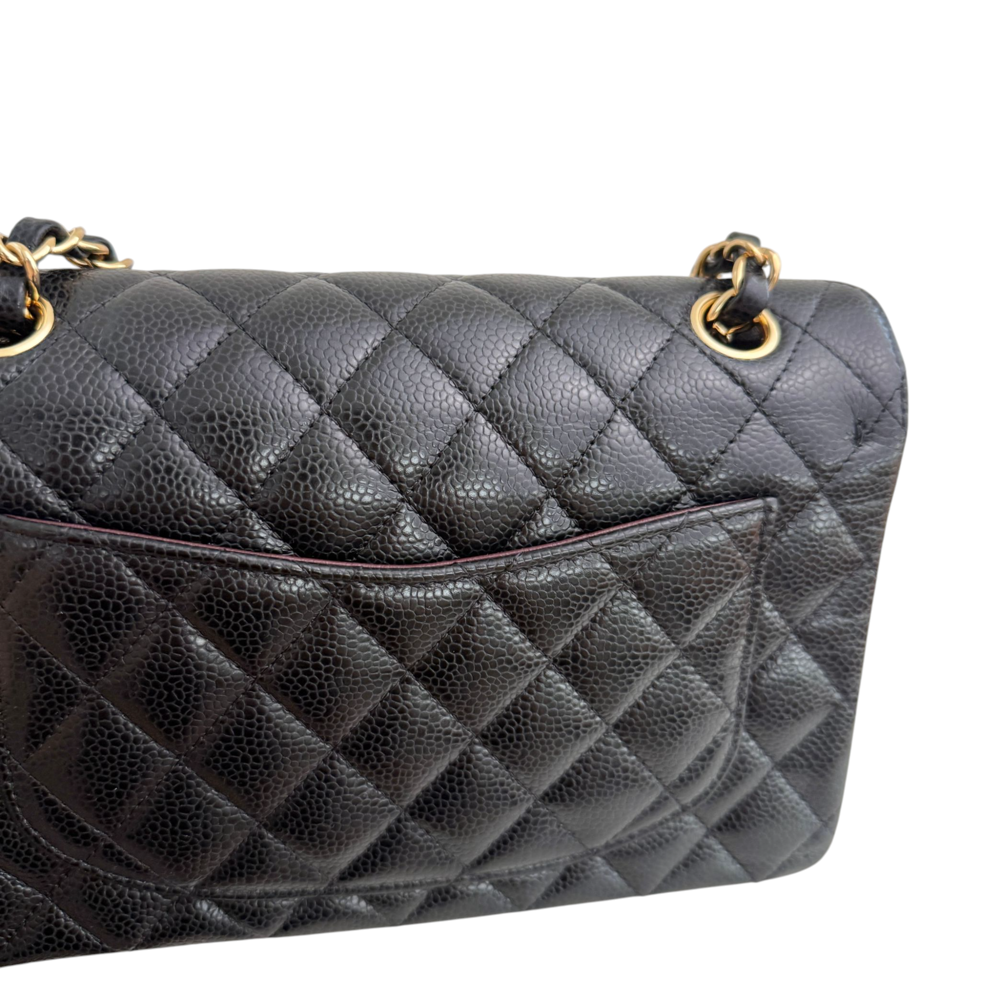 Black quilted handbag with gold hardware on a white background