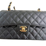 Charger l&#39;image dans la galerie, Black quilted handbag with gold Chanel logo on a white background
