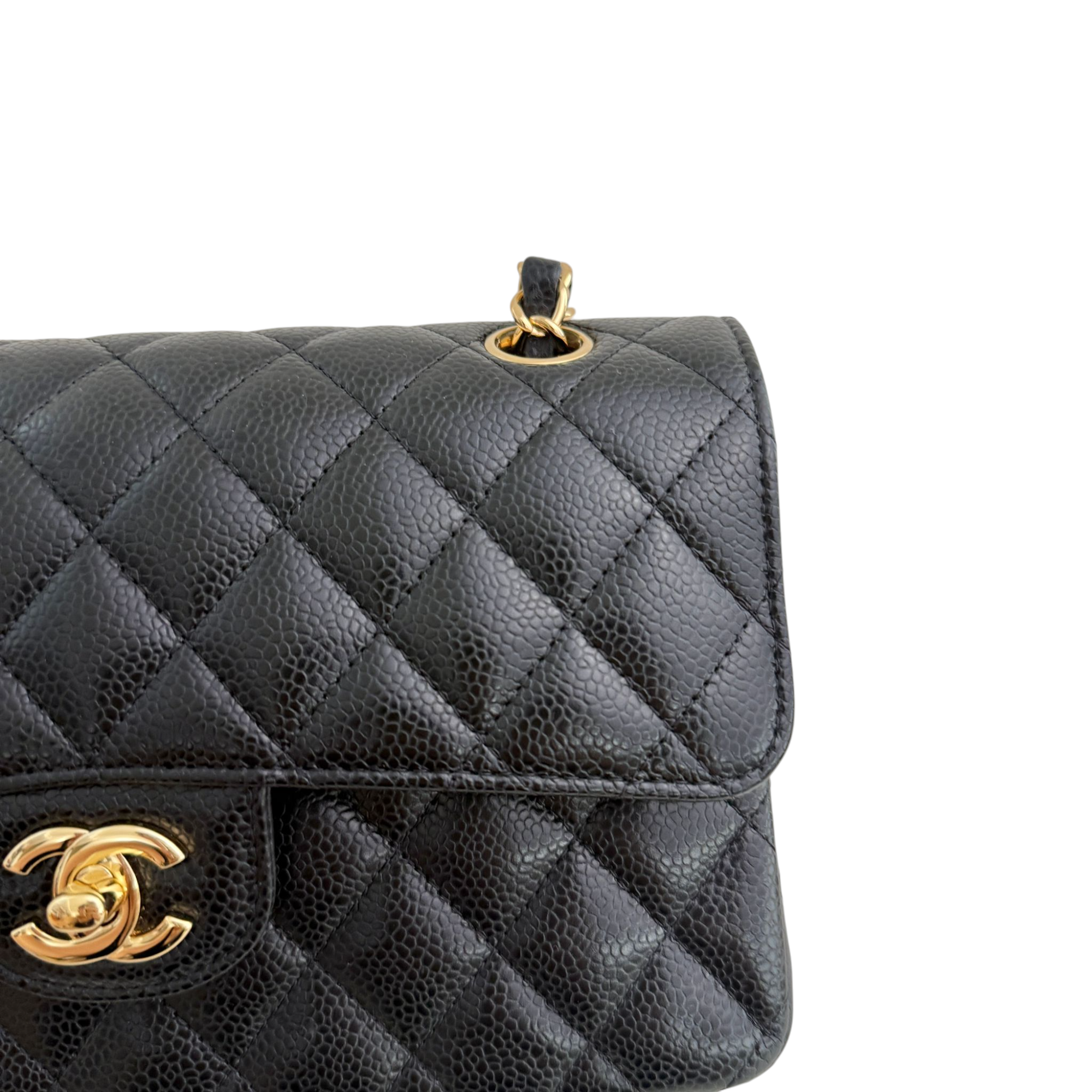 Black quilted handbag with gold hardware on a white background