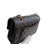 Charger l&#39;image dans la galerie, Black quilted handbag with gold hardware on a white background

