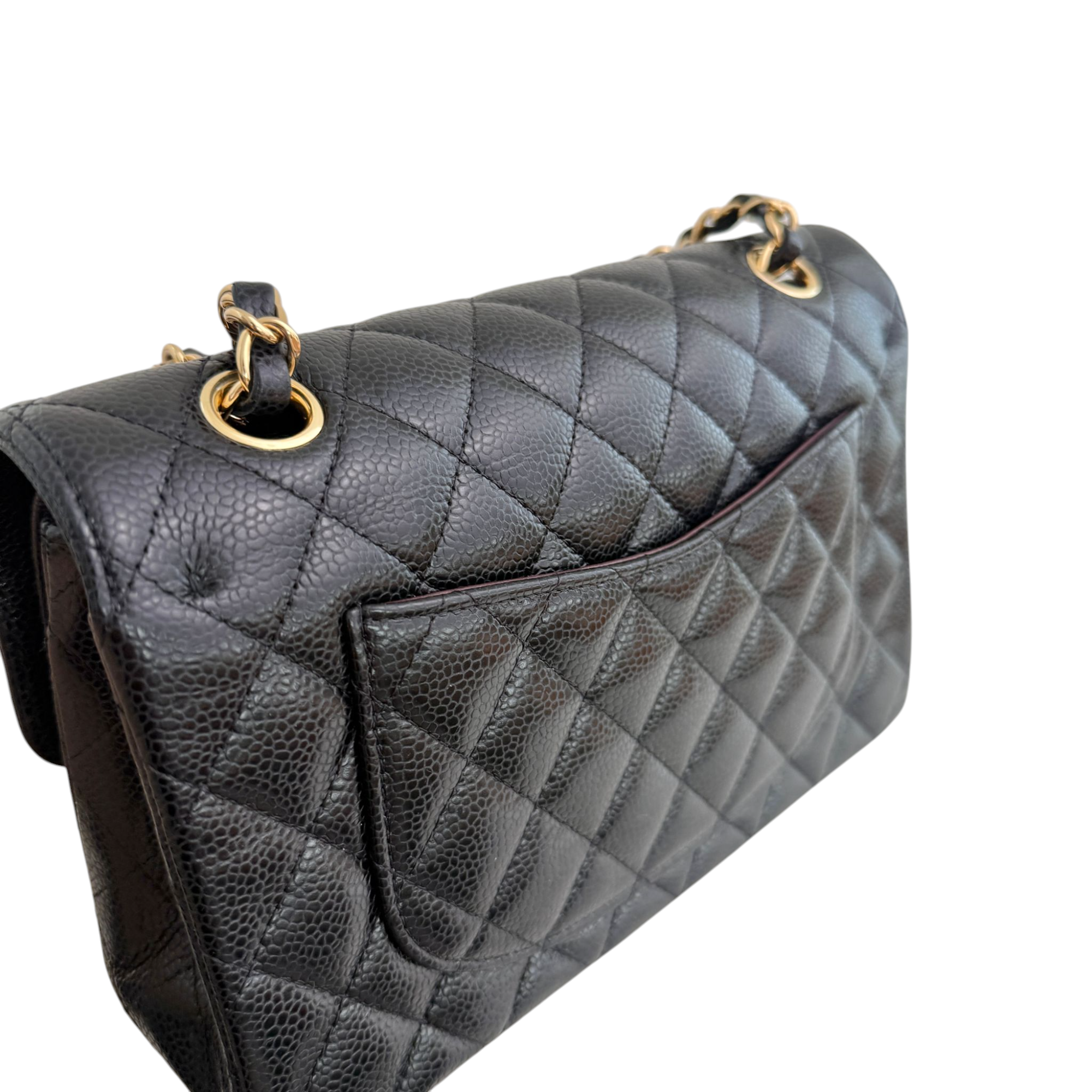 Quilted black handbag with gold hardware on a white background