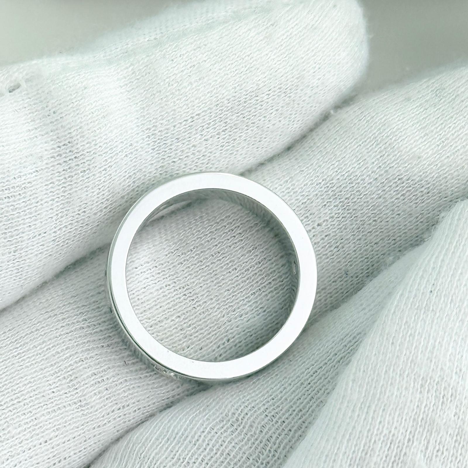 Silver ring on a textured light gray fabric background