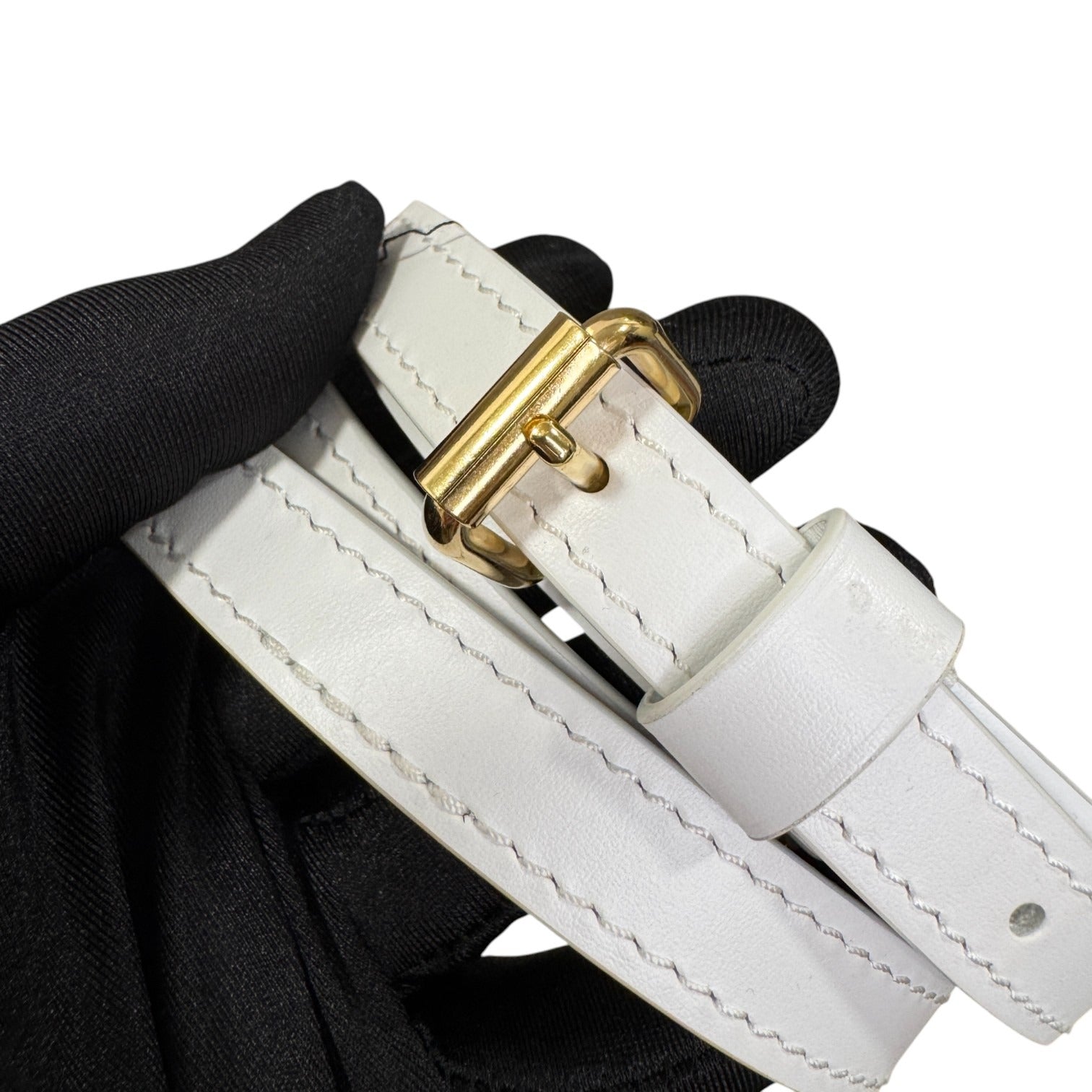 White leather belt with a gold buckle on a white background