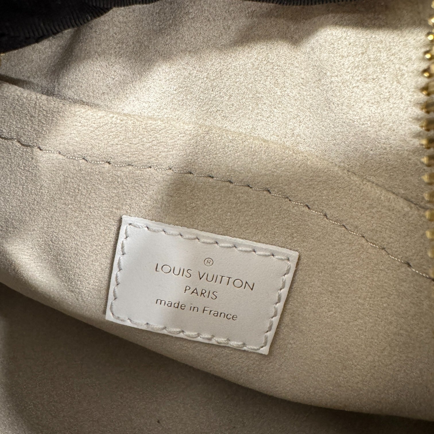 Louis Vuitton label on a beige fabric surface