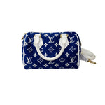 将图片加载到图库查看器，Blue handbag with white monogram pattern on a white background
