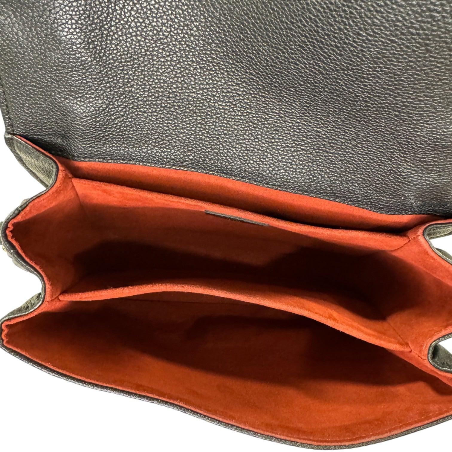 Close-up of a leather bag with a gray exterior and red interior.