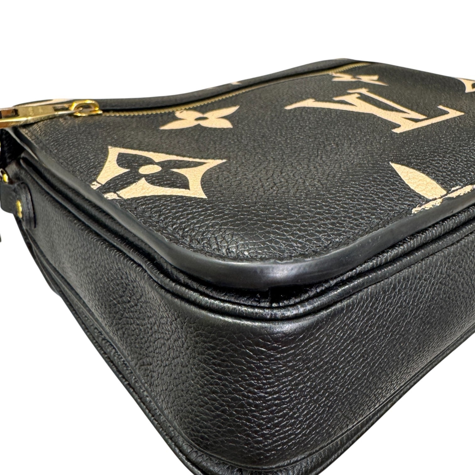 Black leather bag with gold floral patterns on a white background