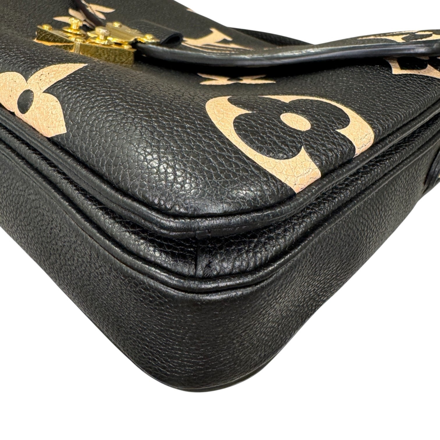 Black leather handbag with gold logo on a white background