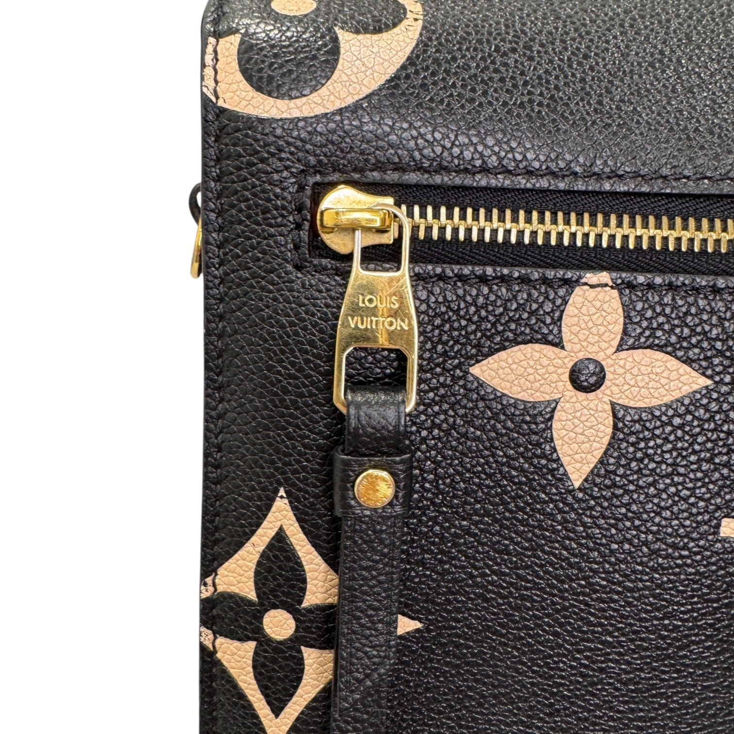 Black leather bag with gold monogram pattern and Louis Vuitton logo on zipper pull.