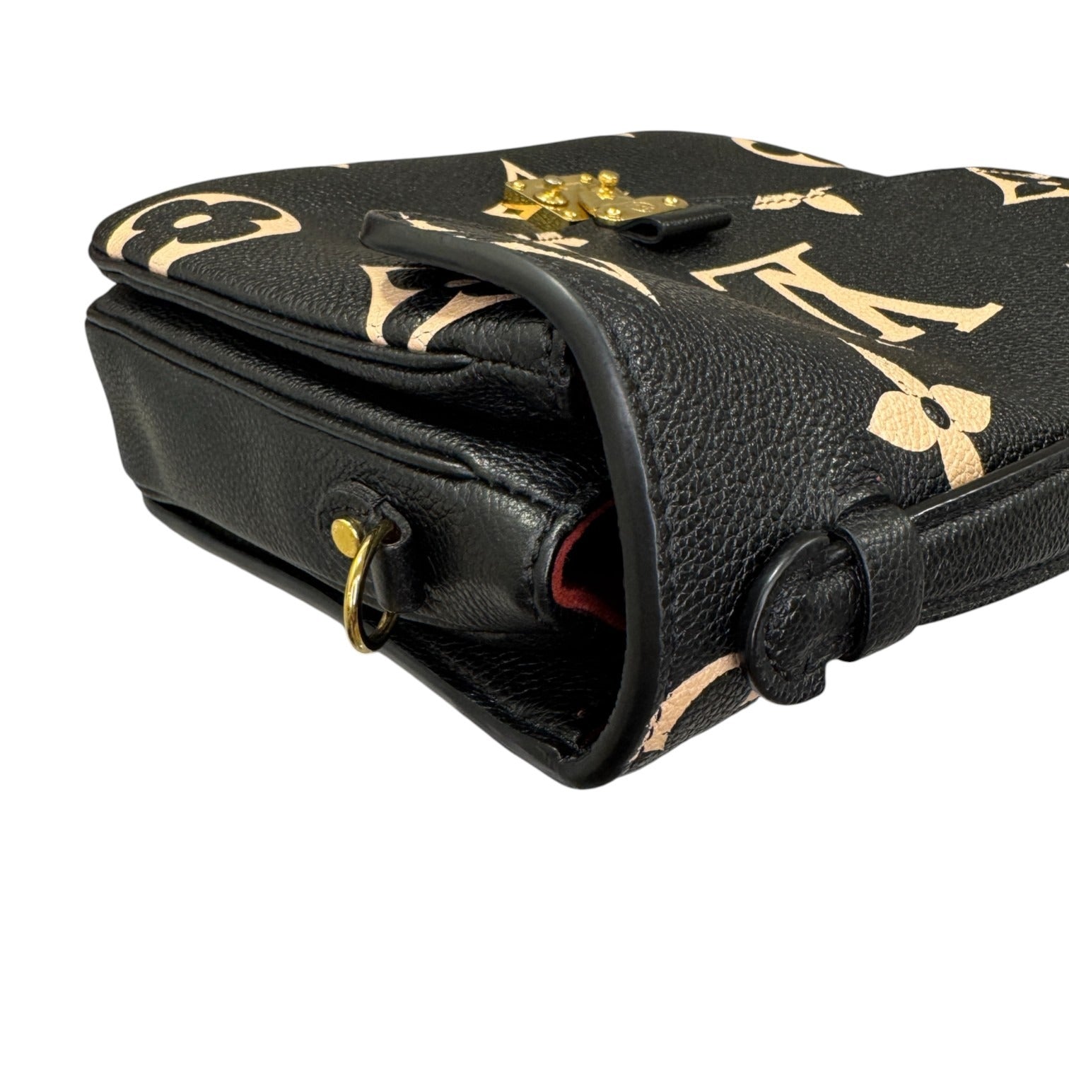 Black leather handbag with gold accents on a white background