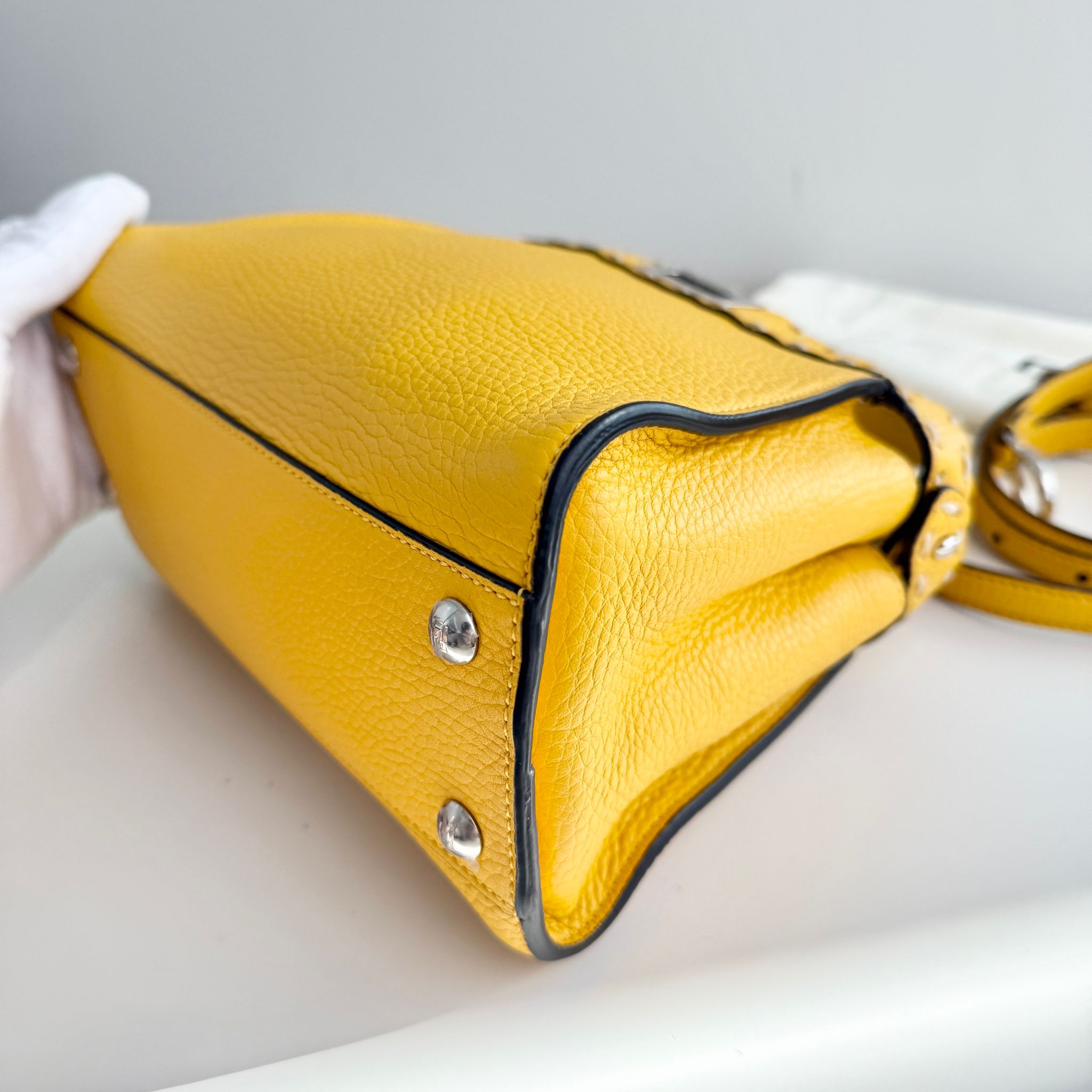 Yellow handbag with a textured surface on a light gray background