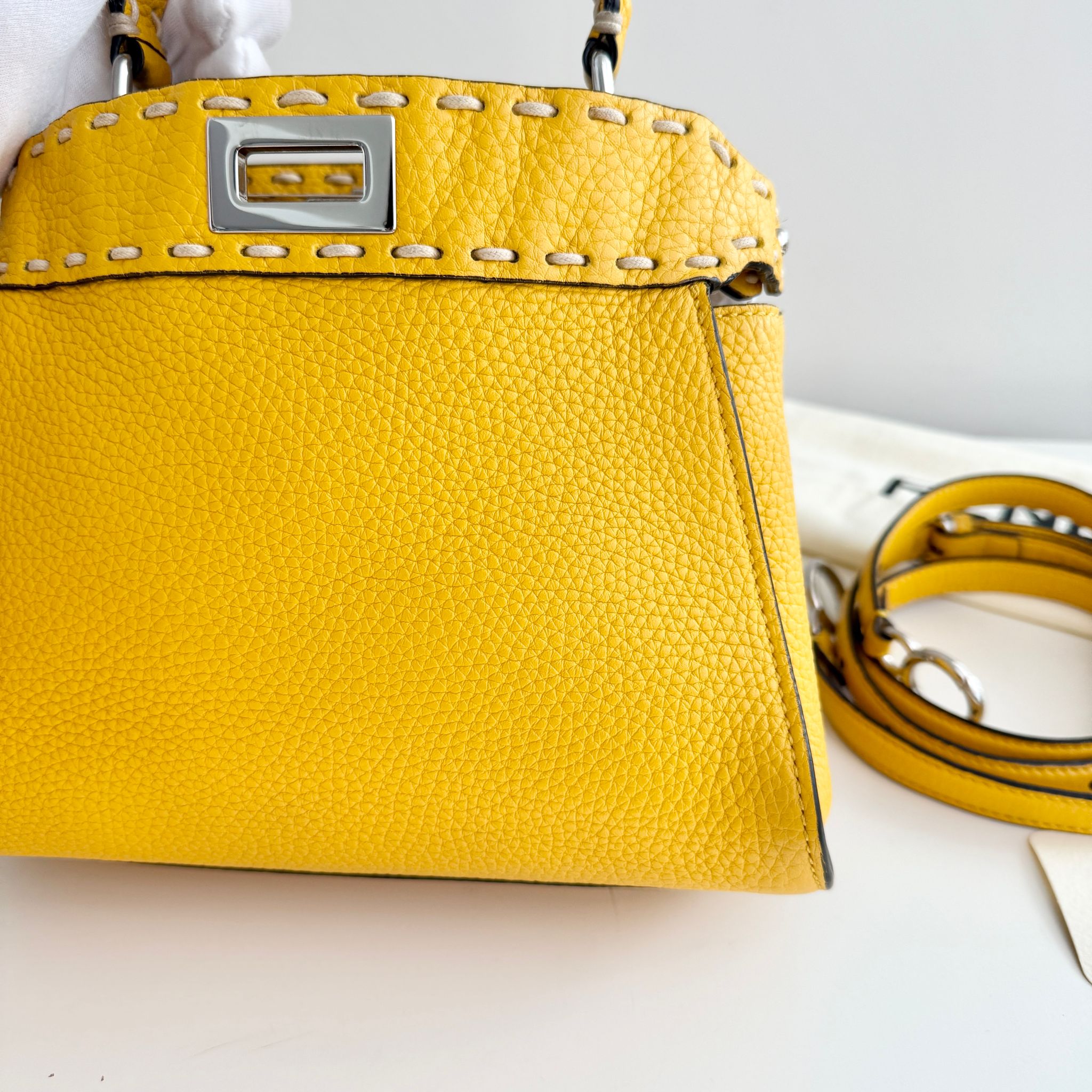 Yellow handbag with a strap on a white background