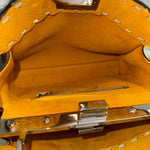 将图片加载到图库查看器，Close-up of a yellow leather handbag with a silver clasp and stitching details.
