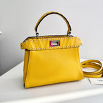 将图片加载到图库查看器，Yellow handbag with studded details on a white surface
