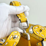 将图片加载到图库查看器，Yellow leather strap with silver buckle held by a gloved hand against a light gray background
