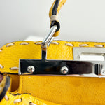 将图片加载到图库查看器，Close-up of a yellow handbag with metal hardware on a white background
