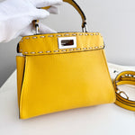 将图片加载到图库查看器，Yellow handbag with a silver clasp held by a gloved hand on a white background
