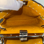 将图片加载到图库查看器，Close-up of a yellow handbag with a gloved hand holding the handle.
