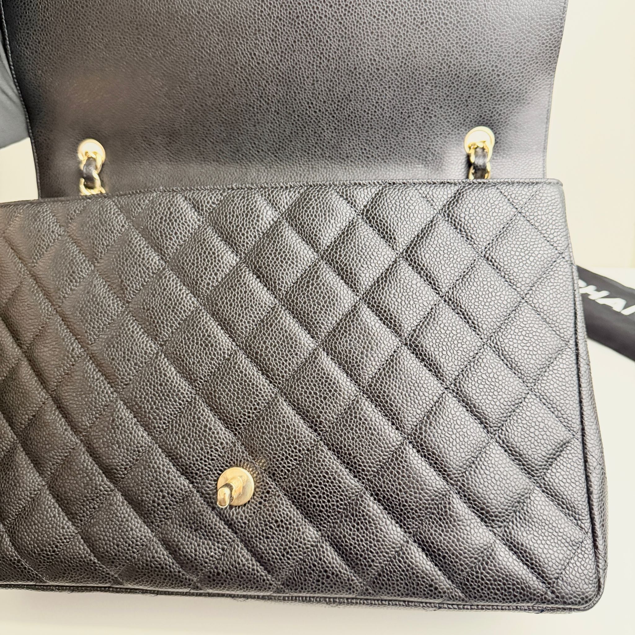 Quilted gray handbag with gold hardware on a light background