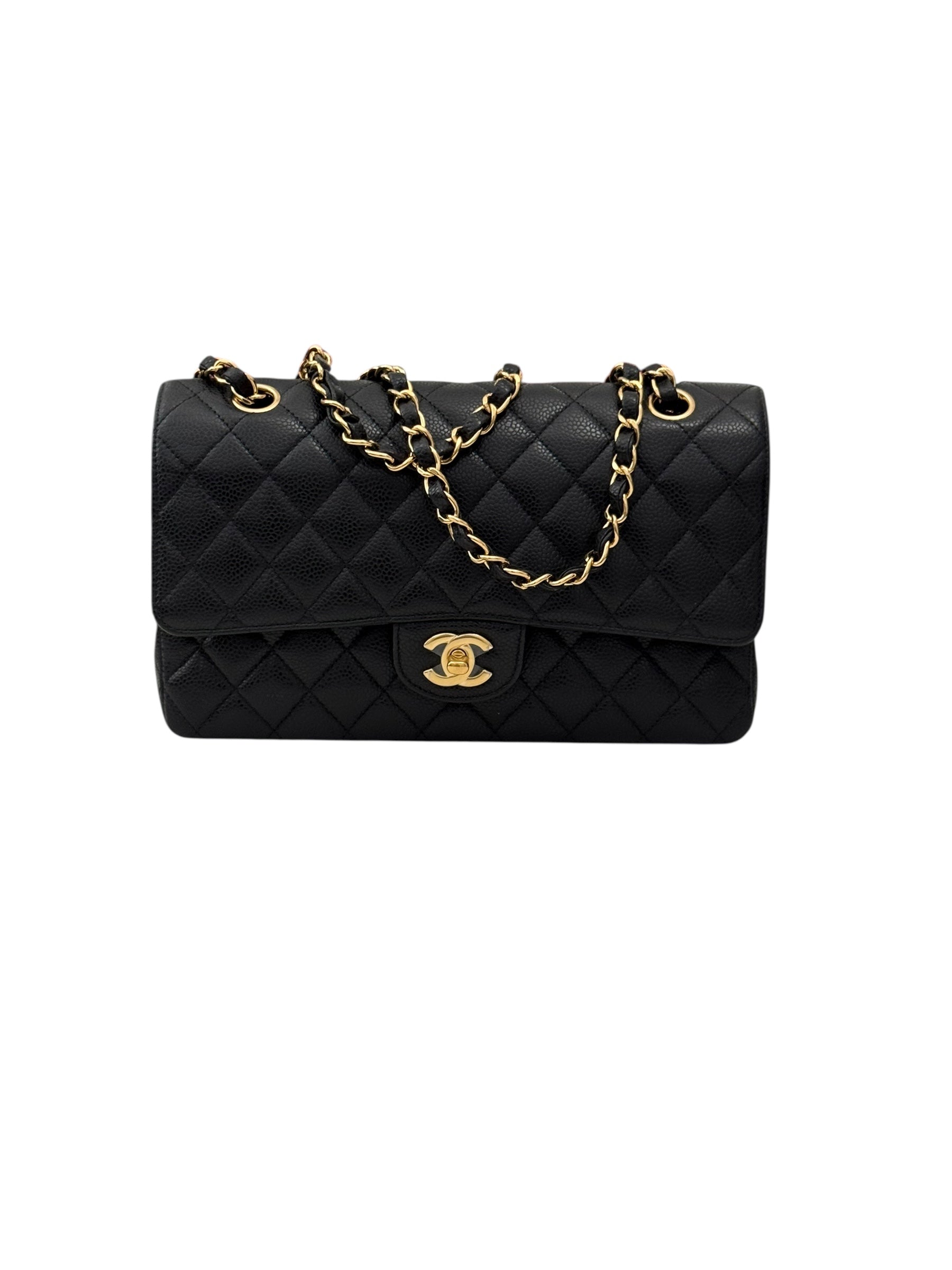 Black quilted handbag with gold chain and clasp on a white background