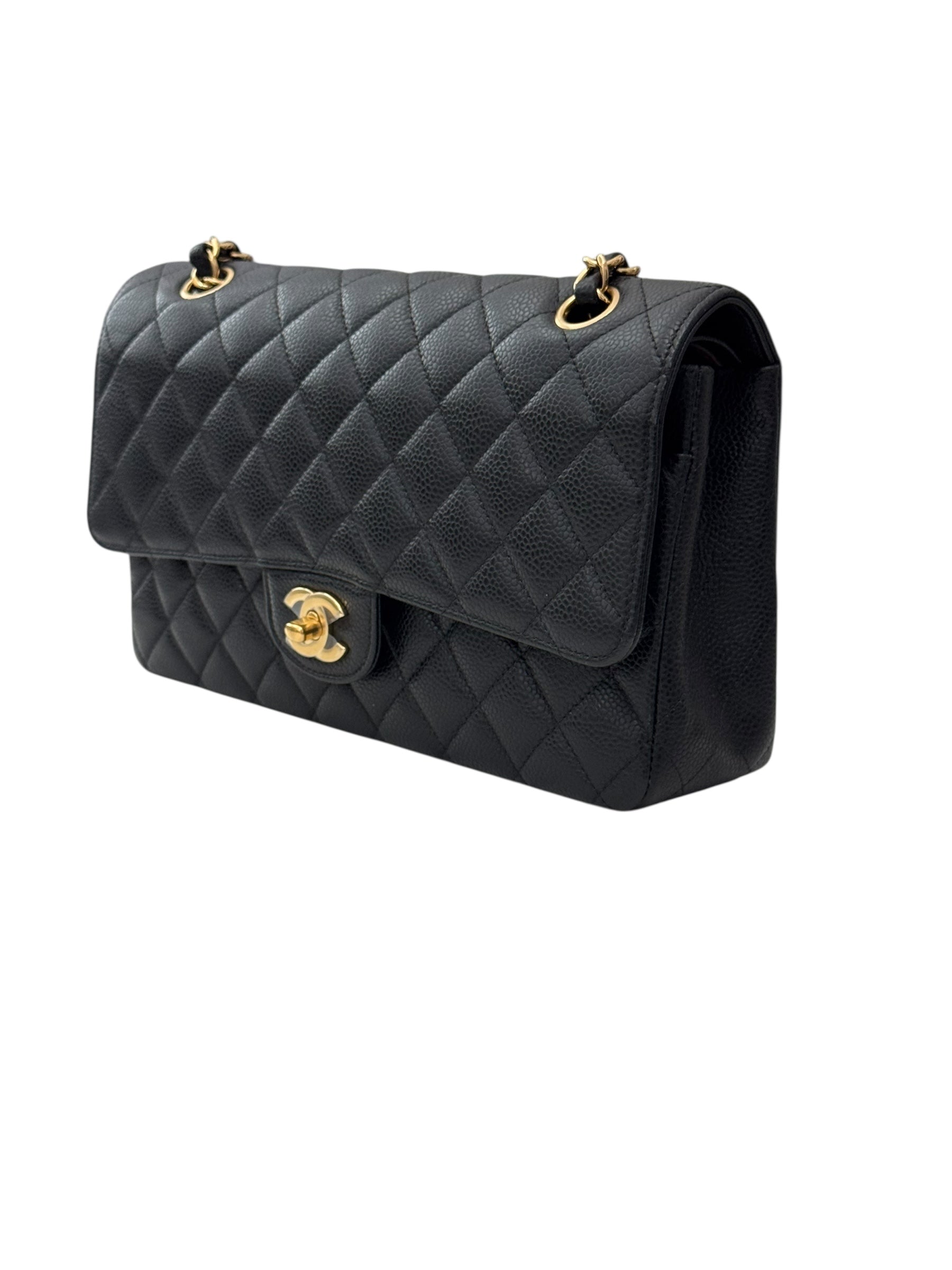 Black quilted handbag with gold hardware on a white background