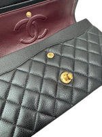 将图片加载到图库查看器，Close-up of a Chanel handbag with quilted black leather and gold hardware.
