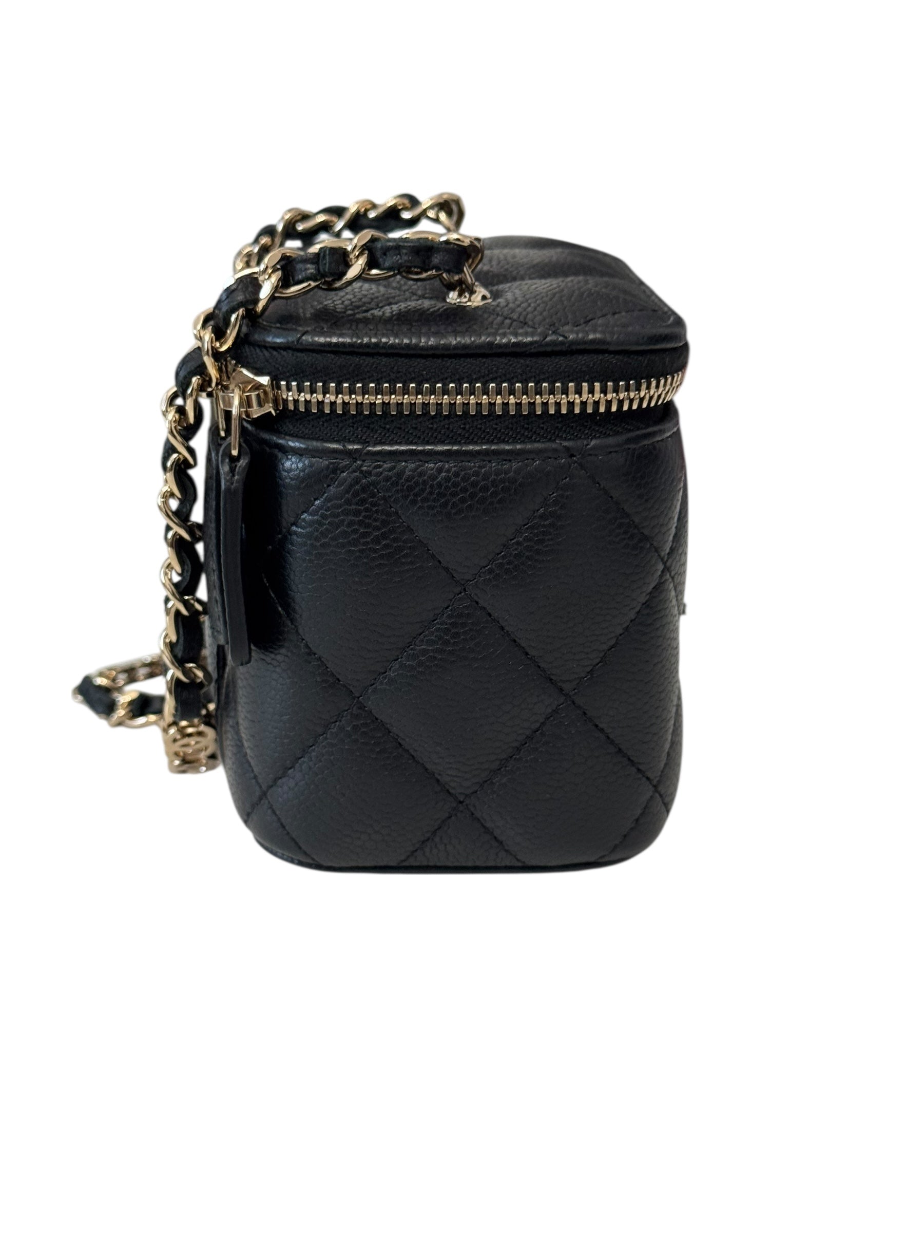 Black quilted handbag with gold chain strap on a white background