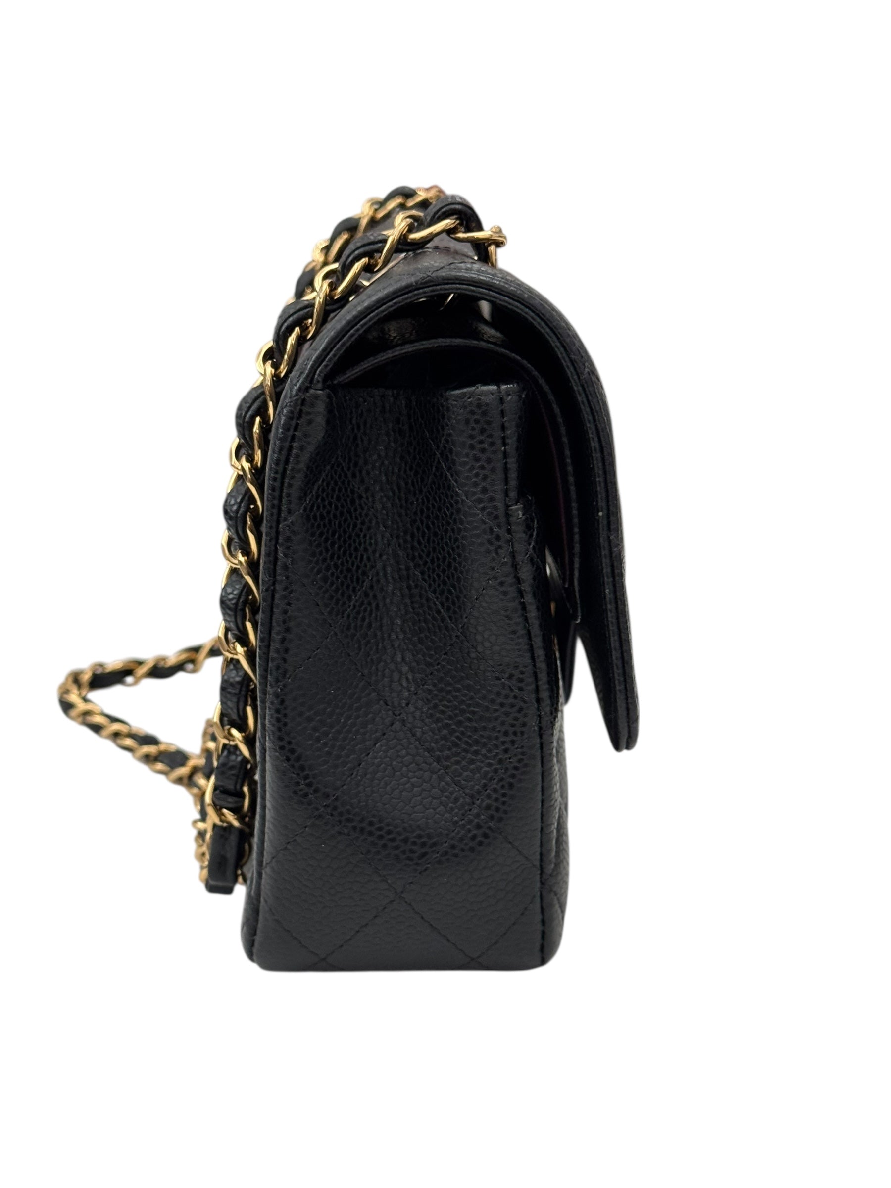 Black quilted handbag with gold chain strap on a white background