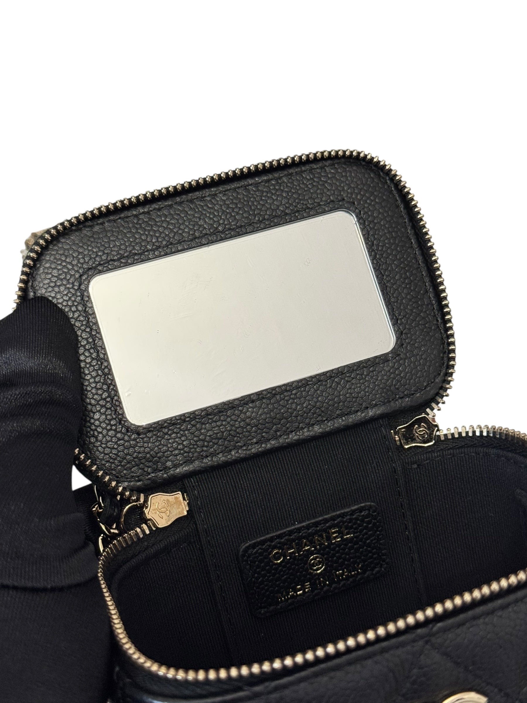Black Chanel handbag with a reflective patch on a white background