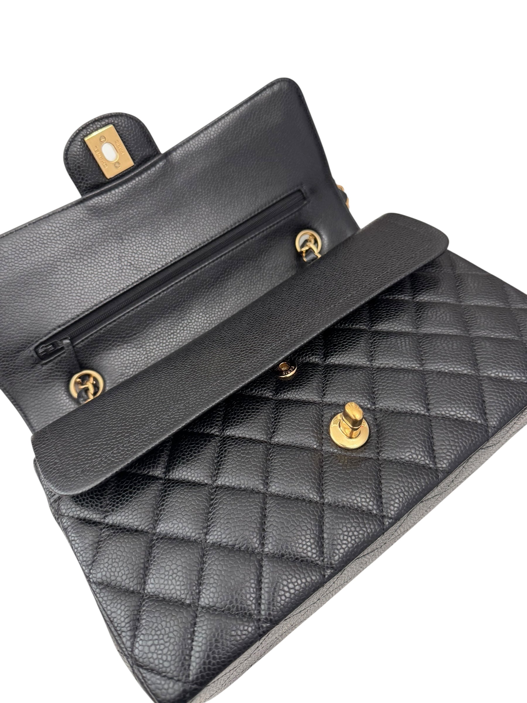 Black quilted handbag with gold hardware on a white background