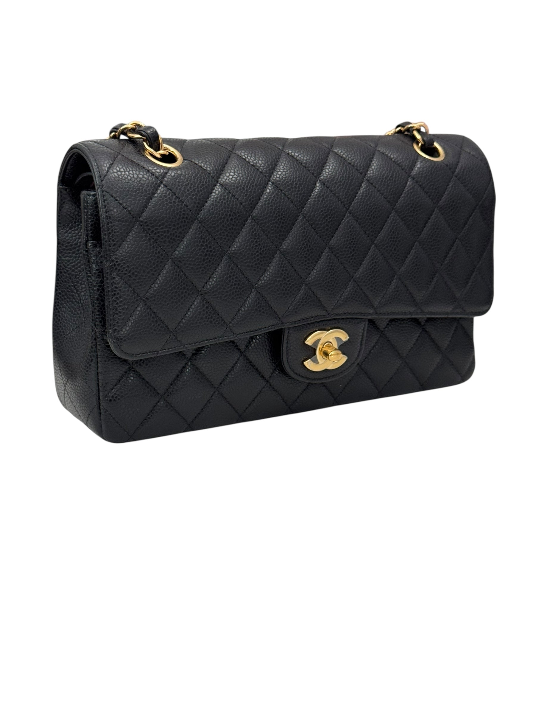 Black quilted handbag with gold hardware on a white background