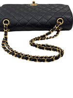将图片加载到图库查看器，Black quilted handbag with a gold chain strap on a white background
