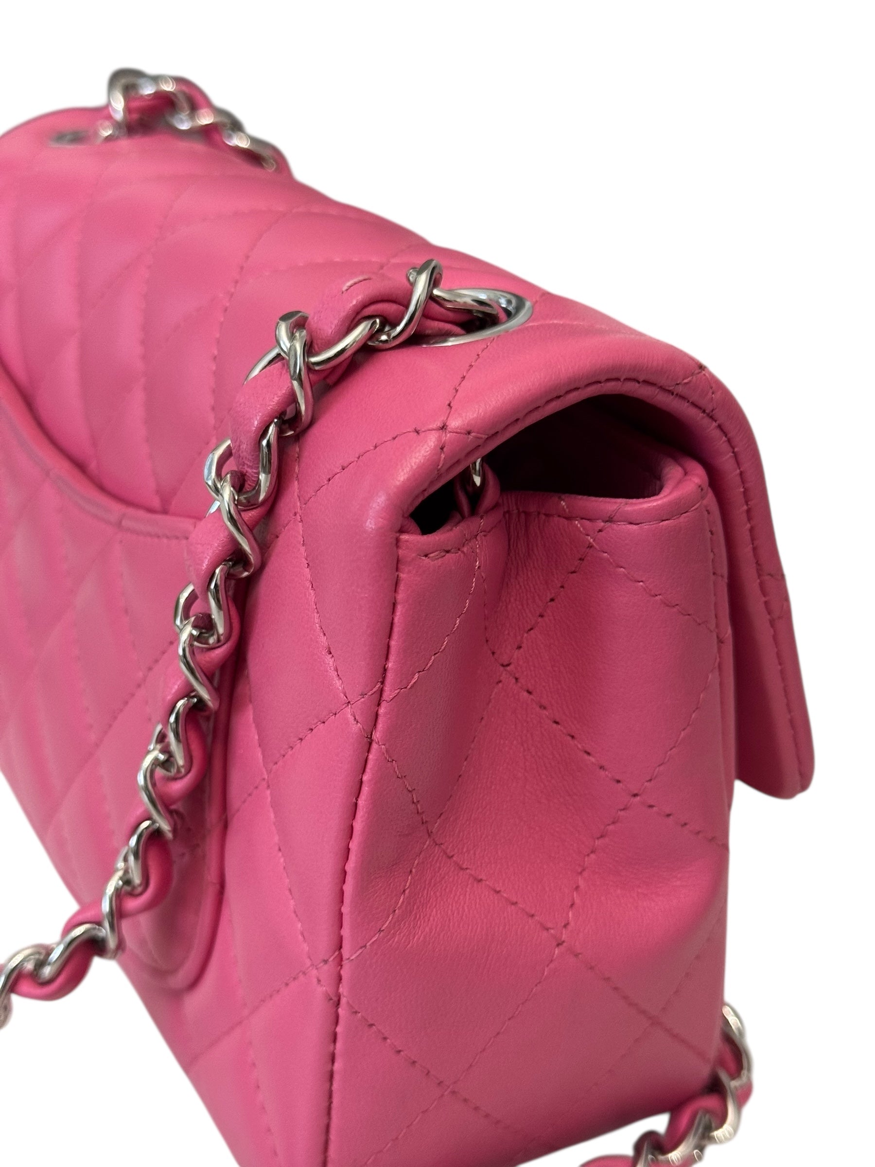 Pink handbag with silver chain detail on a white background