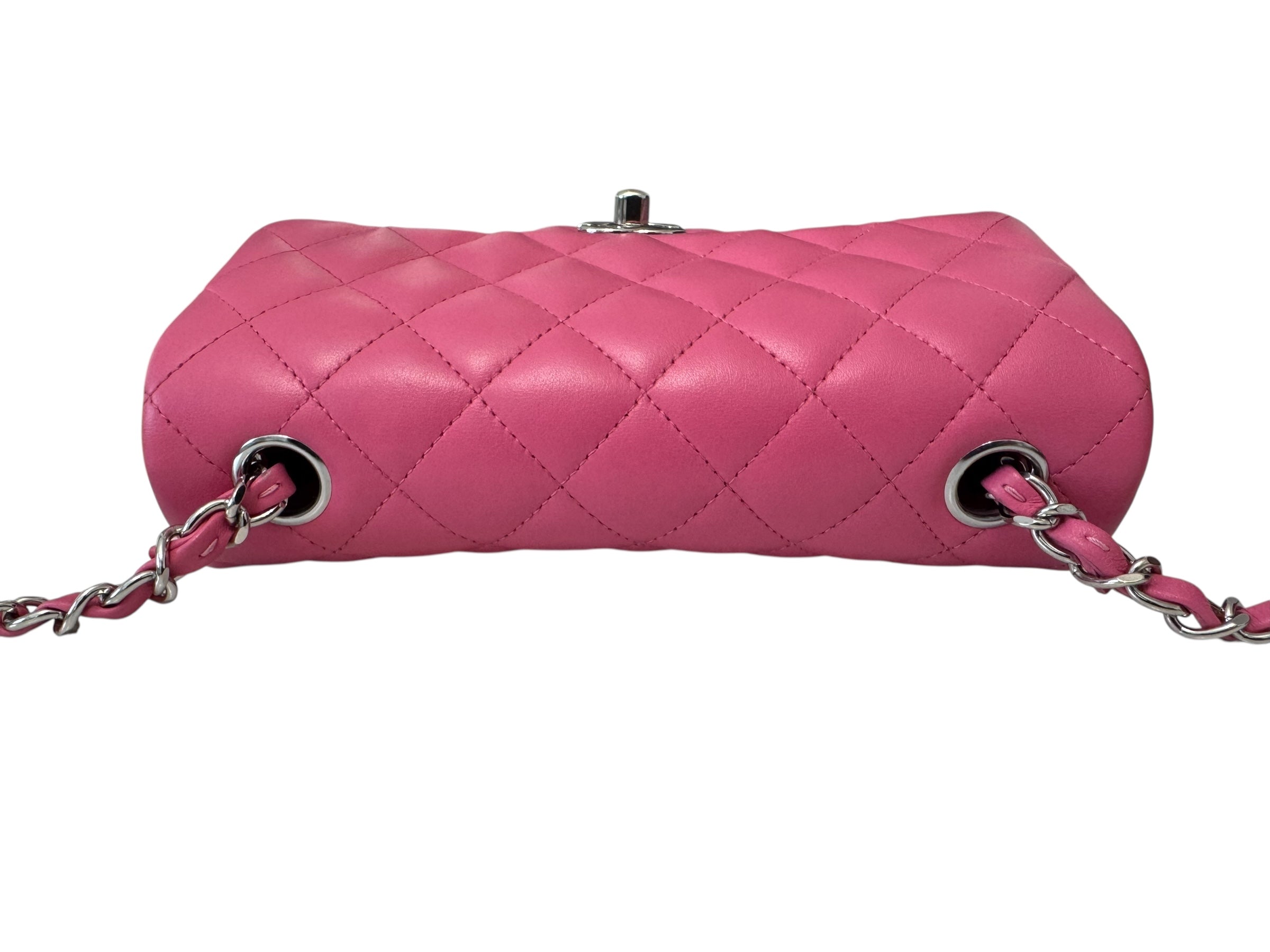 Pink quilted handbag with a chain strap on a white background