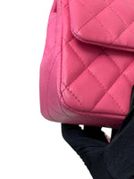 将图片加载到图库查看器，Pink quilted handbag held by a person wearing a black sleeve.
