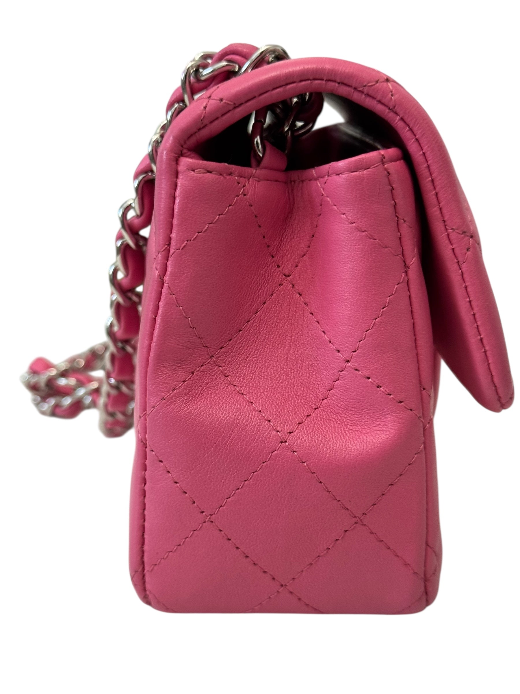 Pink quilted handbag with a chain strap on a white background