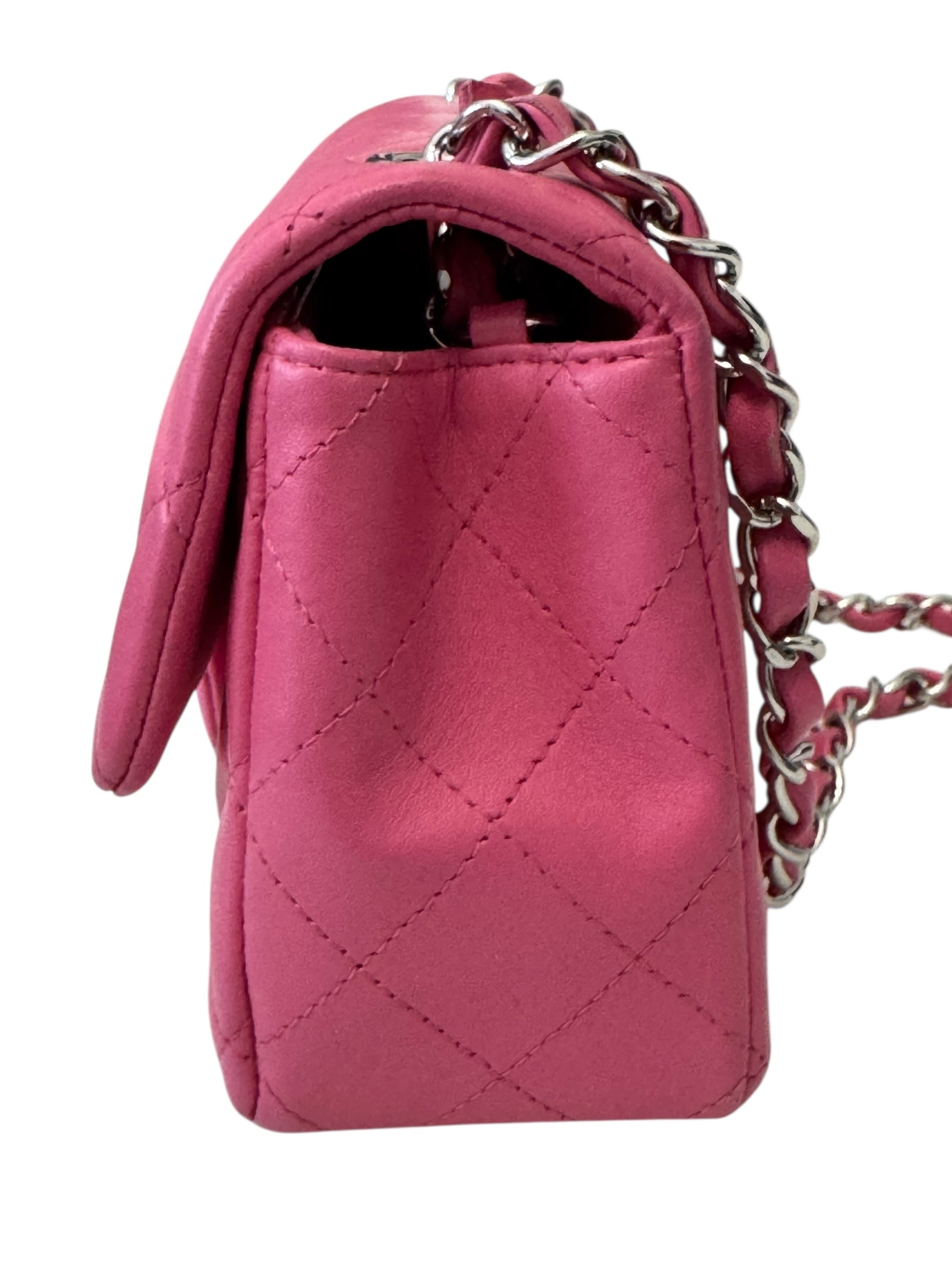 Pink quilted handbag with a chain strap on a white background