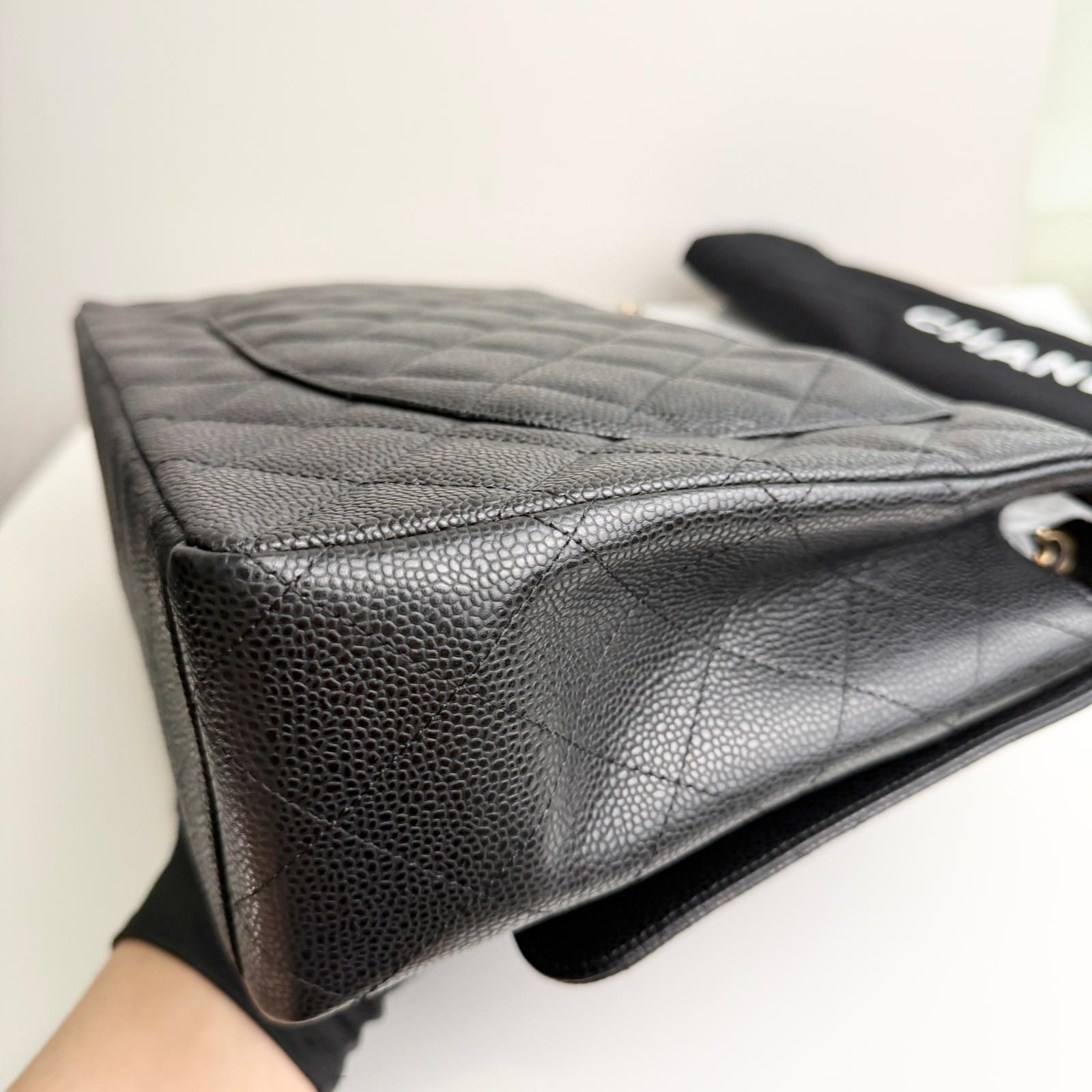 Black quilted handbag with visible brand name on a white background