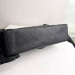 将图片加载到图库查看器，Black textured handbag held by a gloved hand on a white surface
