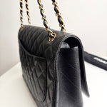 将图片加载到图库查看器，Black quilted handbag with gold chain strap on a white surface
