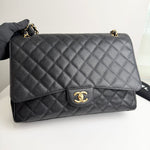 将图片加载到图库查看器，Quilted black handbag with gold hardware on a white background
