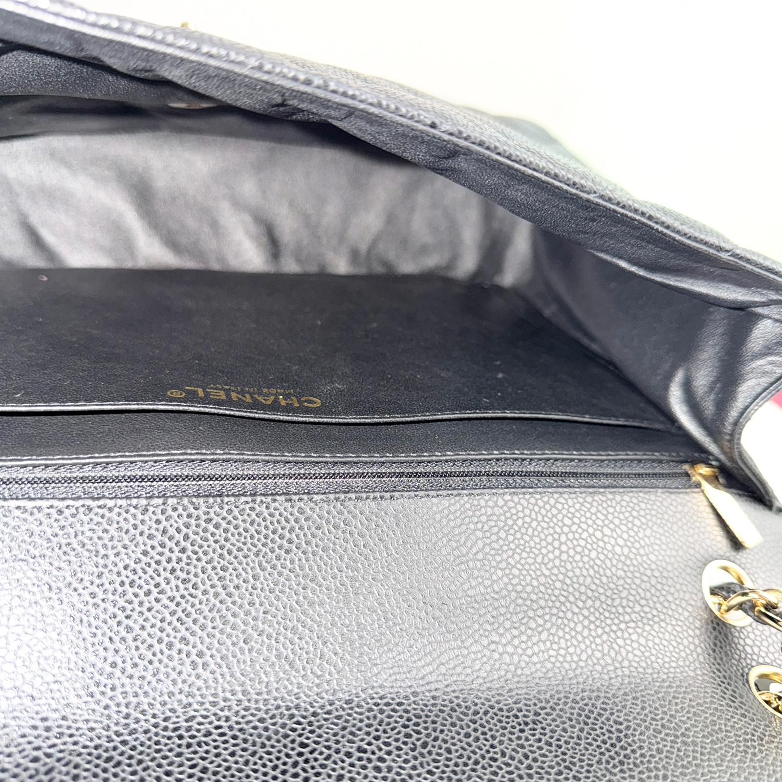 Close-up of a gray leather handbag with gold hardware, featuring the brand name 'Chanel'.