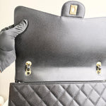 将图片加载到图库查看器，Black handbag with gold hardware held by a person wearing gray gloves.
