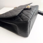 将图片加载到图库查看器，Black quilted handbag on a white background
