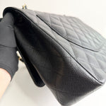 将图片加载到图库查看器，Black quilted handbag held by a gloved hand on a white background
